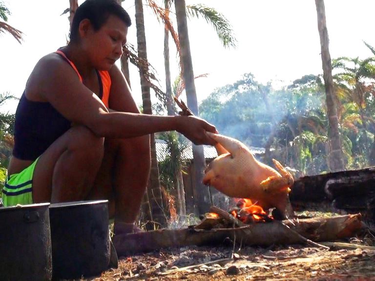 Mujer Nukak cocinando
